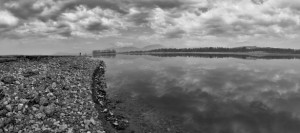 Rocky lake shore and clouds, black and white artistically balanced nature shot