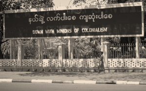 Sign reads: Down with the Minions of Colonialism in Burmese and English