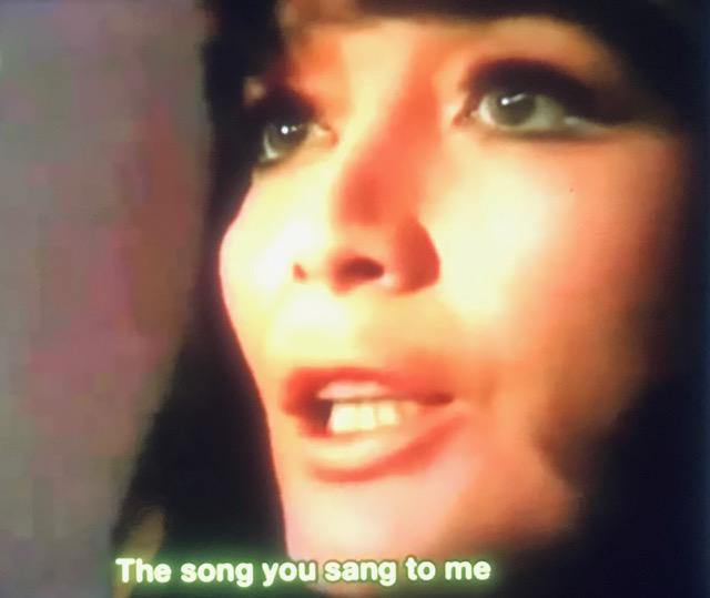 Image of a young white woman with her face turned towards the left. She's got dark hair and large eyebrows. Underneath her headshot words read The Song You Sang to Me.