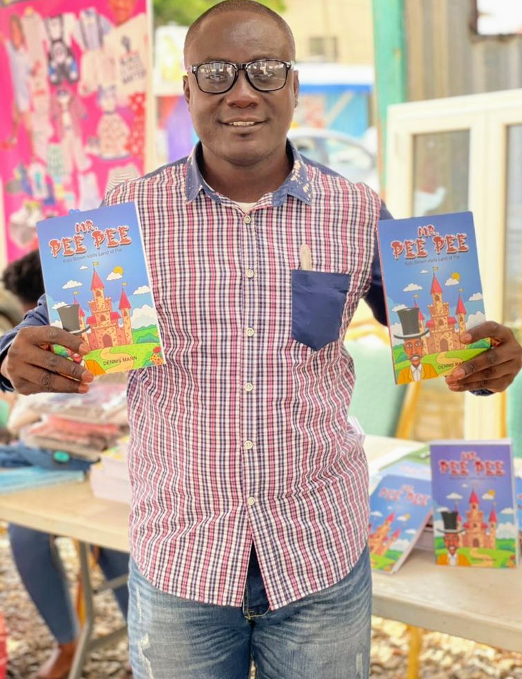 Young Black man with glasses and a plaid top and jeans holding some Mr. Pee Pee books. 