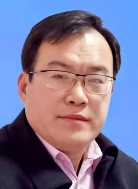 East Asian man's headshot. He's older middle aged and has short black hair and reading glasses. He's wearing a pink collared shirt and a black coat.