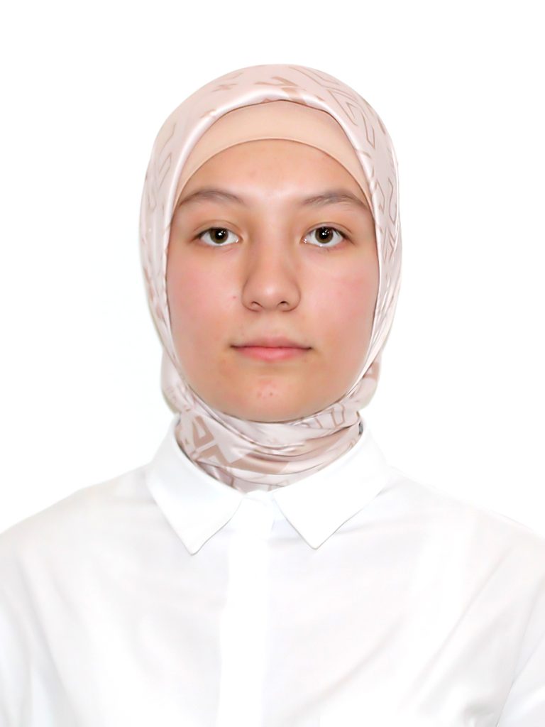 Young Central Asian woman with a headscarf and brown eyes. She's wearing a white collared shirt. 