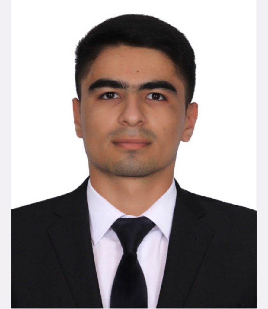 Young Central Asian man with short black hair, brown eyes, a white collared dress shirt, and a black coat and tie. 