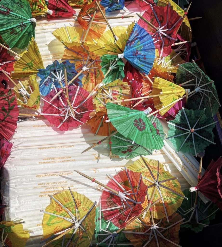 Little colored cocktail umbrellas and packaged straws.