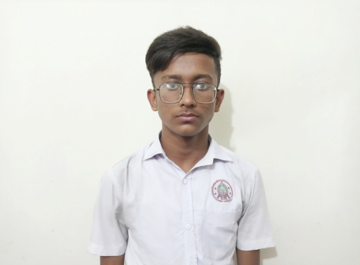 South Asian boy with reading glasses and short brown hair and a white collared school uniform