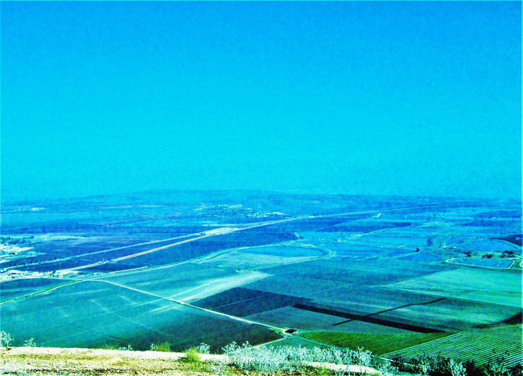 Blue-green tinted look at farm fields from a mountaintop vista