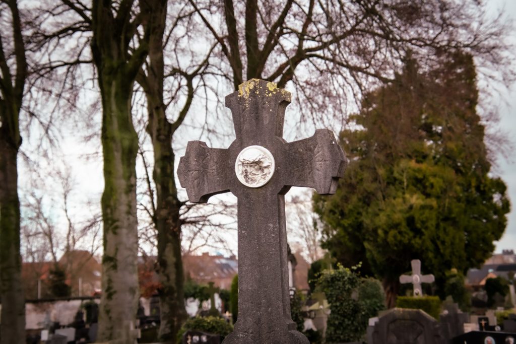 Cross in a cemetery under trees. 