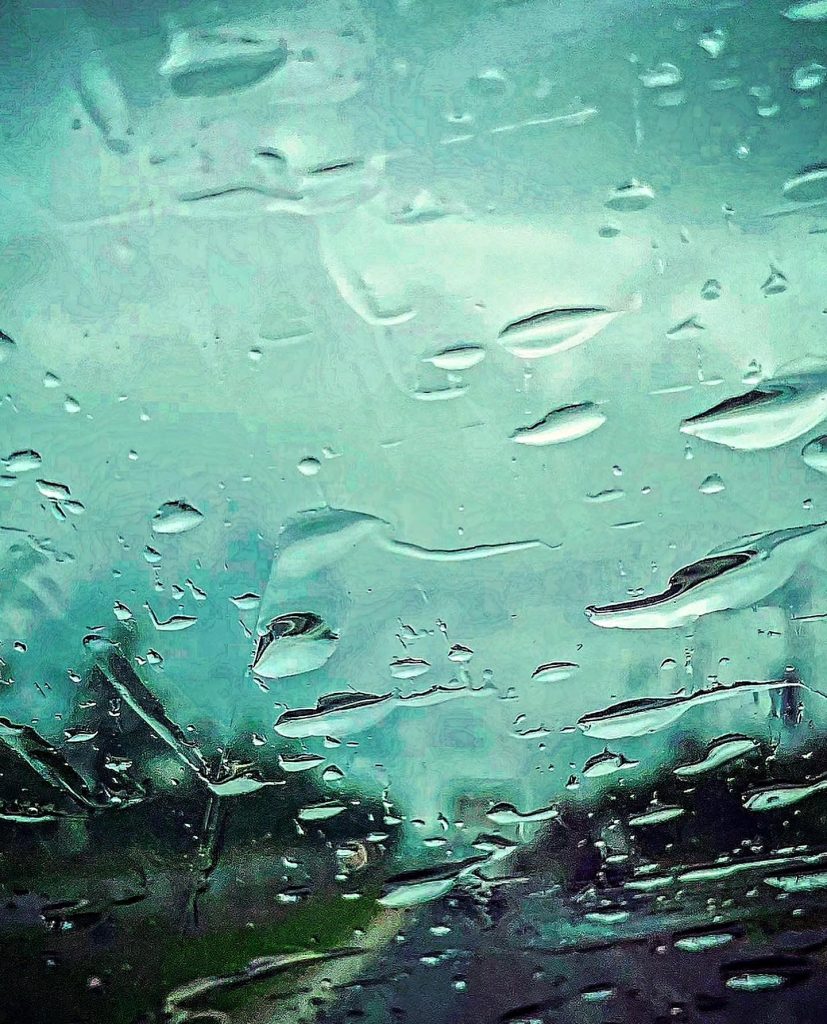 Drops of water on a glass with a light green background. 