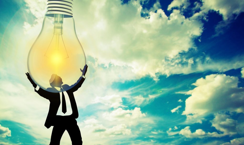 Cartoon image of a man in a suit embracing a light bulb descending from a blue sky with a few wispy cirrus clouds. 