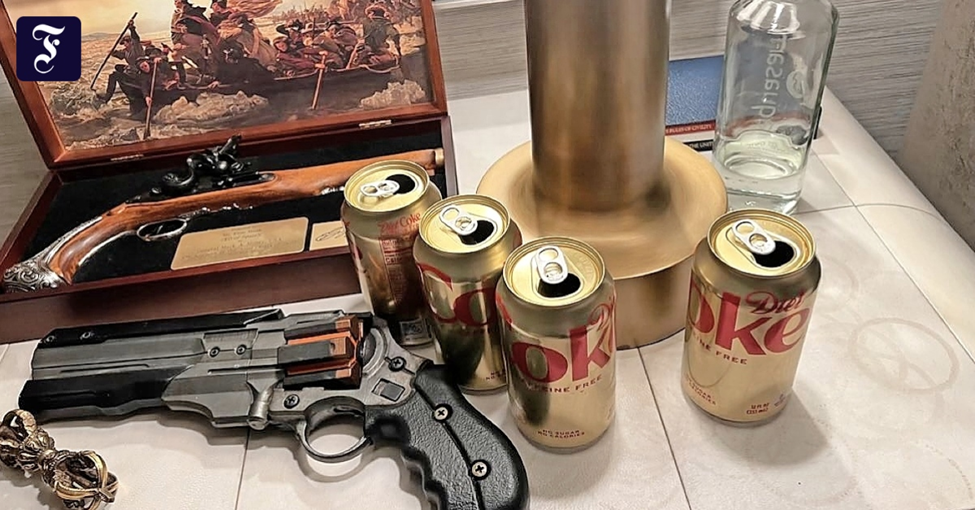 Four Diet Coke cans and water and a gun and a painting of George Washington crossing the Delaware on a night stand. 