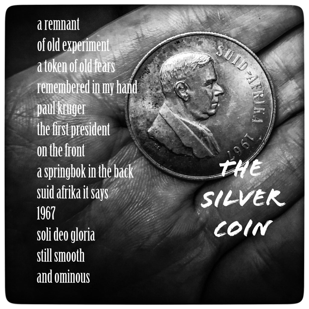 Silver coin from South Africa in someone's palm. Whole image is gray. Text in white reads "The Silver Coin. a remnant of old experiment a token of old fears remembered in my hand paul kruger the first president on the front a springbok in the back suid afrika it says 1967 soli deo gloria still smooth and ominous" 