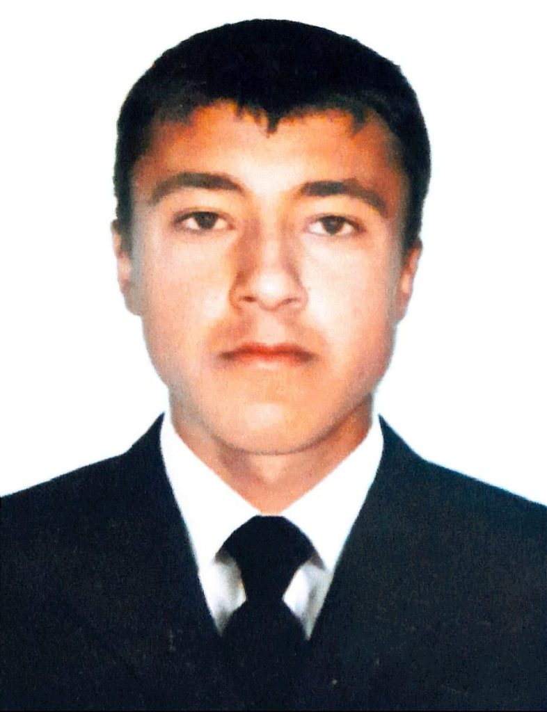Central Asian teen boy with short brown hair, brown eyes, and a black suit and tie.