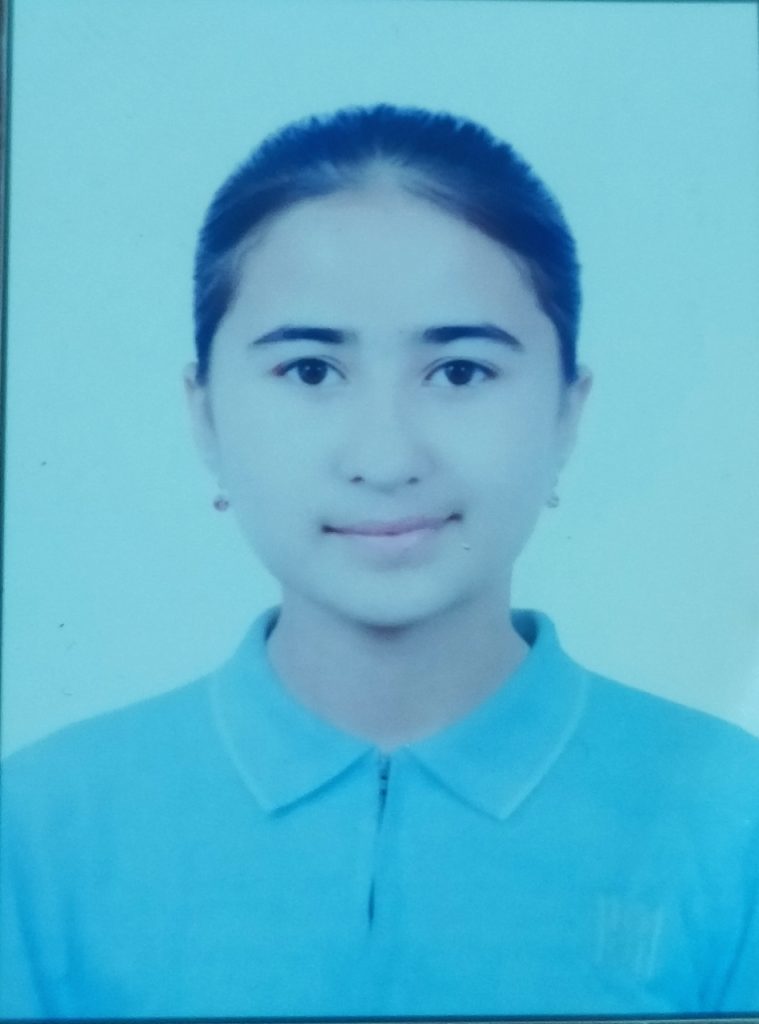 Central Asian teen girl with a blue collared shirt, hair in a bun behind her head, brown eyes, and small earrings. 