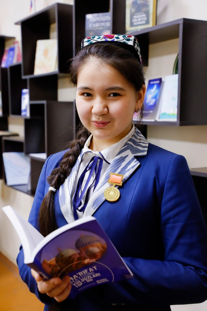 Central Asian teen girl with dark hair in a blue jacket.