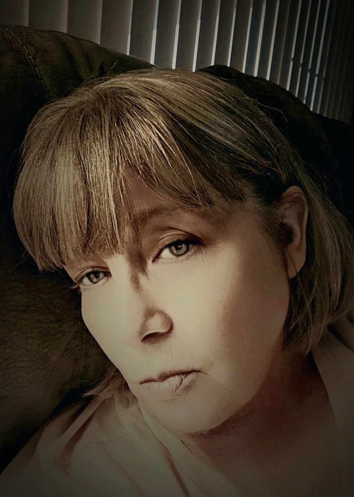 Gently faded image of a light skinned woman with light brown bangs, light brown eyes, and short hair. 