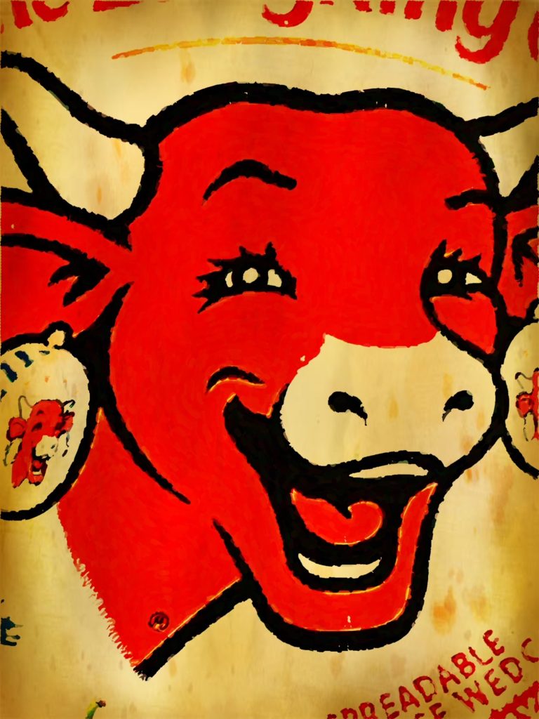 Closeup of a smiling face of a red cow on a Laughing Cow dairy product package. 