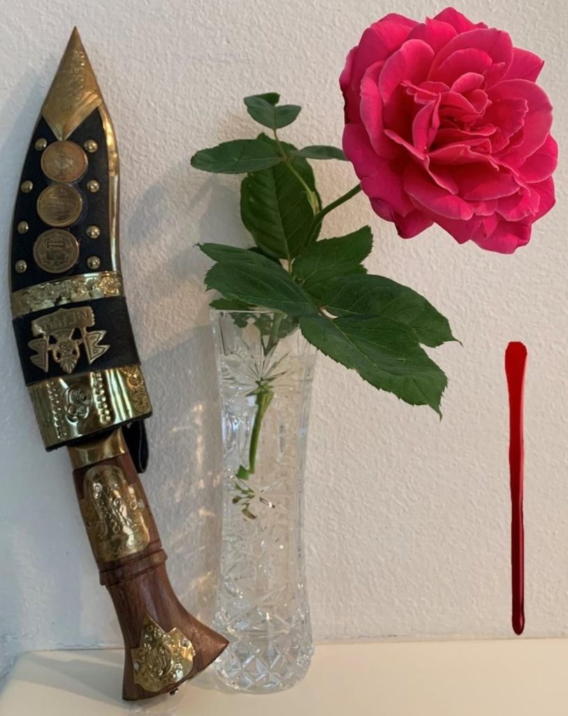 Dagger sheathed in a decorated sheath, rose in a glass vase, splotch of blood or red paint. 