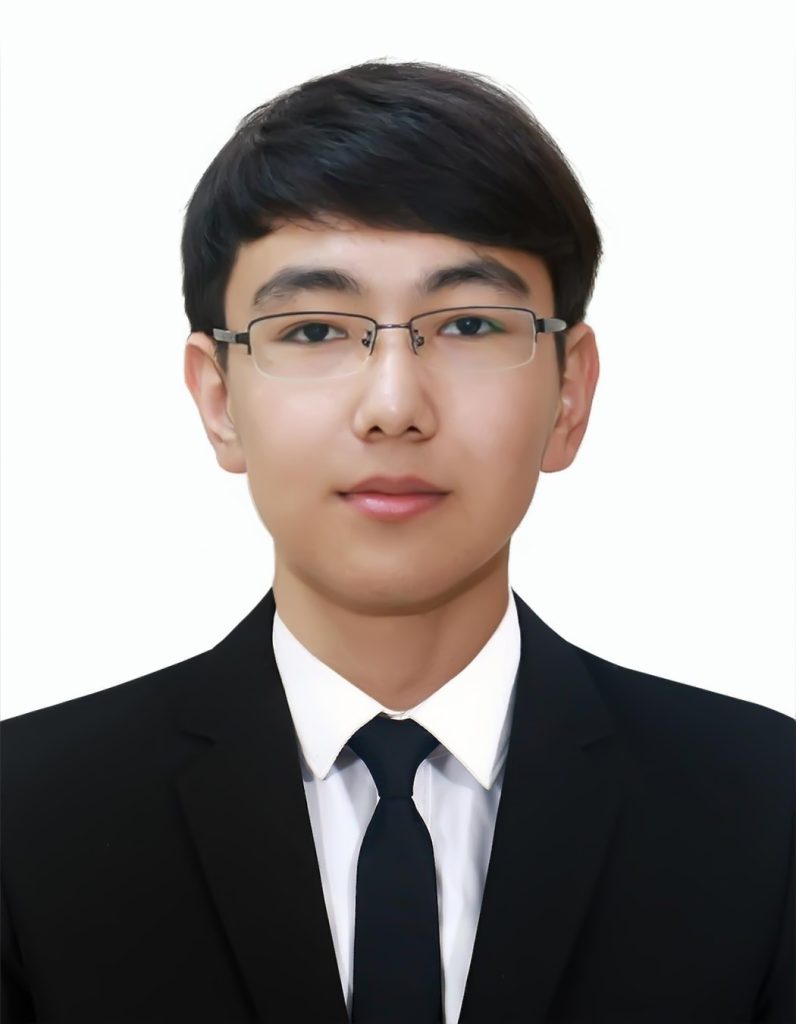 Young teen Central Asian boy, short dark hair, reading glasses, and a white collared shirt and black coat and tie. 