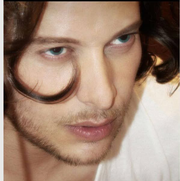 Another hazy, dreamy photograph of a young man with locks of dark hair.