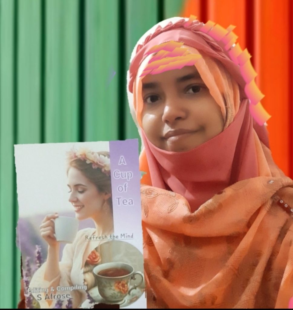 Young South Asian woman in a pink and light orange headscarf holding a book cover where the photo is a woman with flowers in her hair drinking tea. She's in front of red and green curtains.