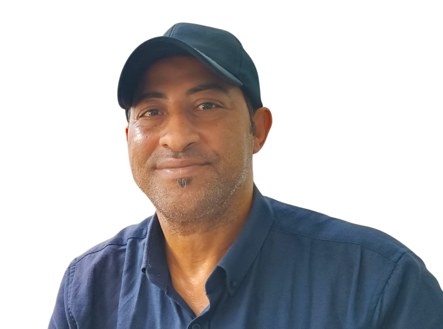 Headshot of a middle aged Arab man in a blue baseball cap and blue collared shirt.