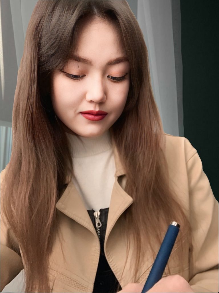 Central Asian young woman with long dark hair and a tan jacket and blouse. 