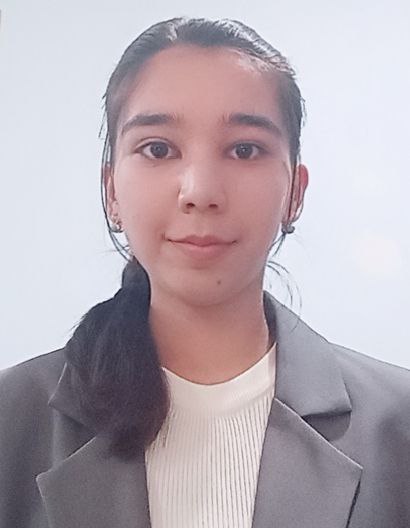 Young Central Asian girl with a dark ponytail and a gray coat over a white top.