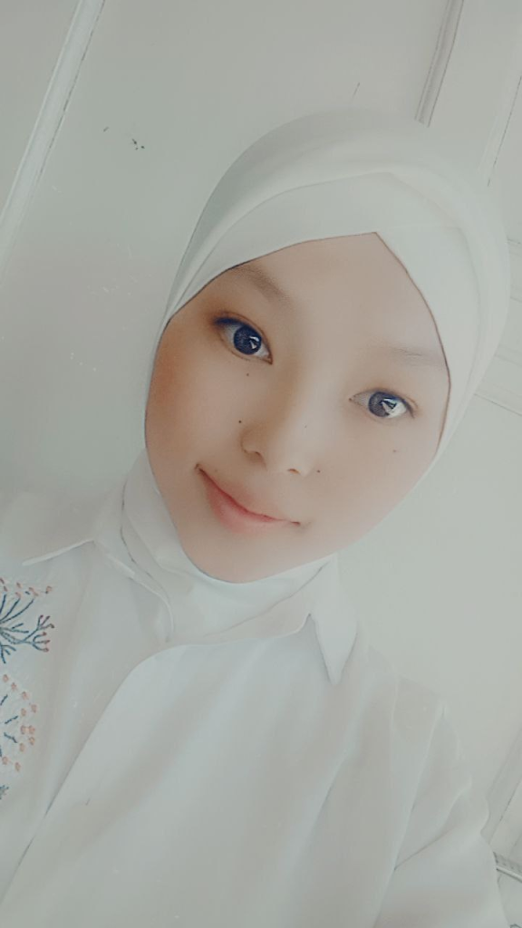 Young Central Asian woman in a white headdress and top. 