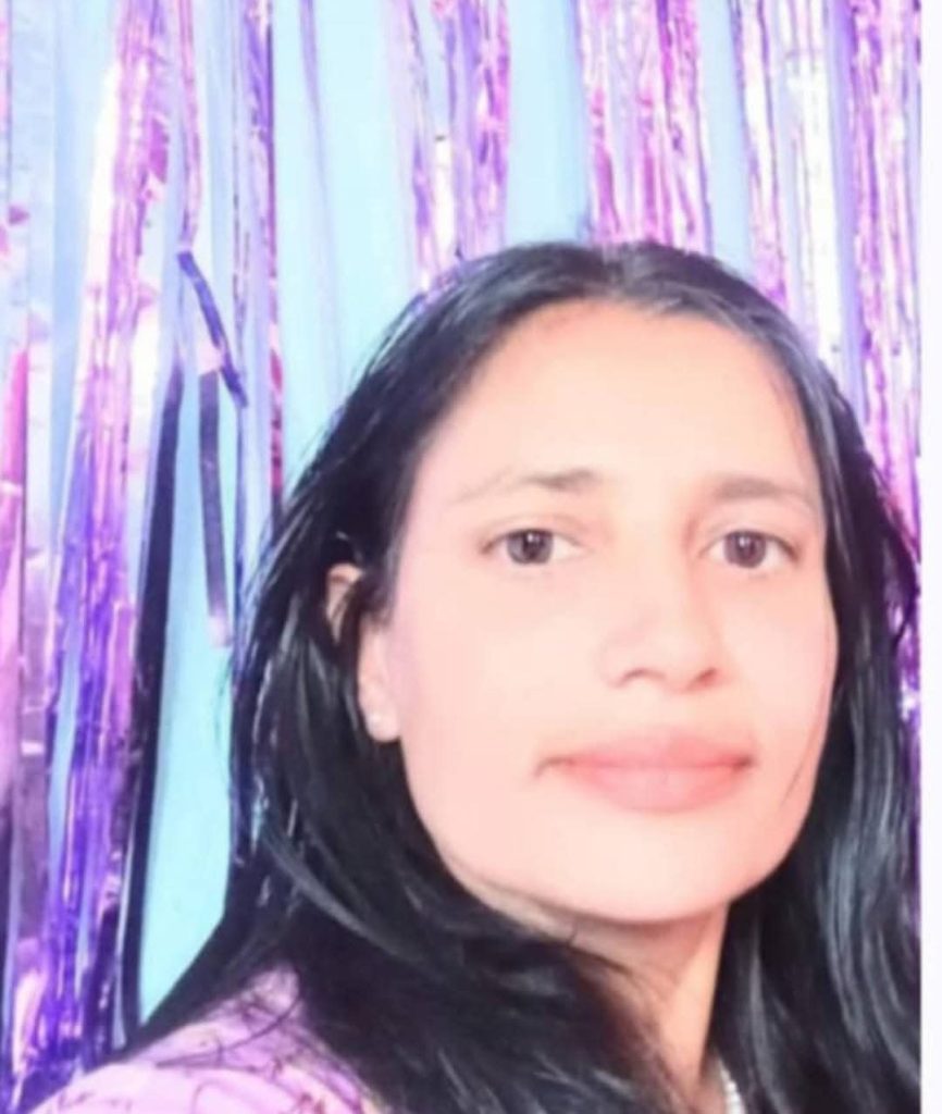 Young South Asian woman with short dark hair, brown eyes, and a purple top against a purple background. 