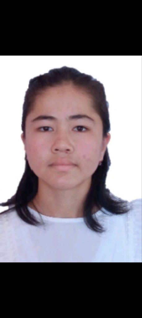 Central Asian woman with shoulder length dark hair and a white top.