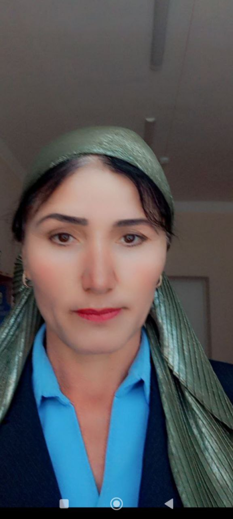Young Central Asian woman in a green headscarf and blue and white top.