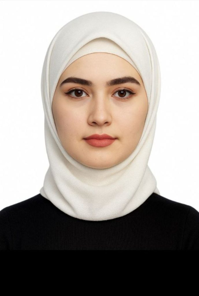 Young Central Asian woman with brown eyes and a white headscarf and black top. 