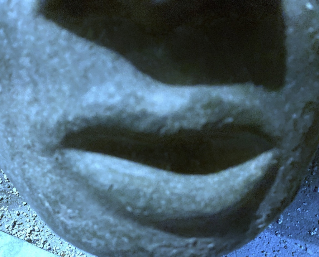 Close-up image of a clay sculpture of a human face. Each photo here is of a face from a slightly different angle, close up near the mouth.