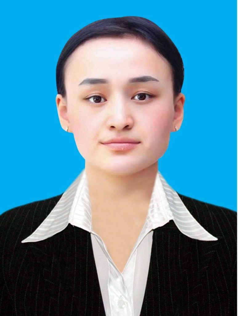 Young Central Asian woman with her hair up in a bun, brown eyes, and small earrings. She's in a white blouse and black jacket. 