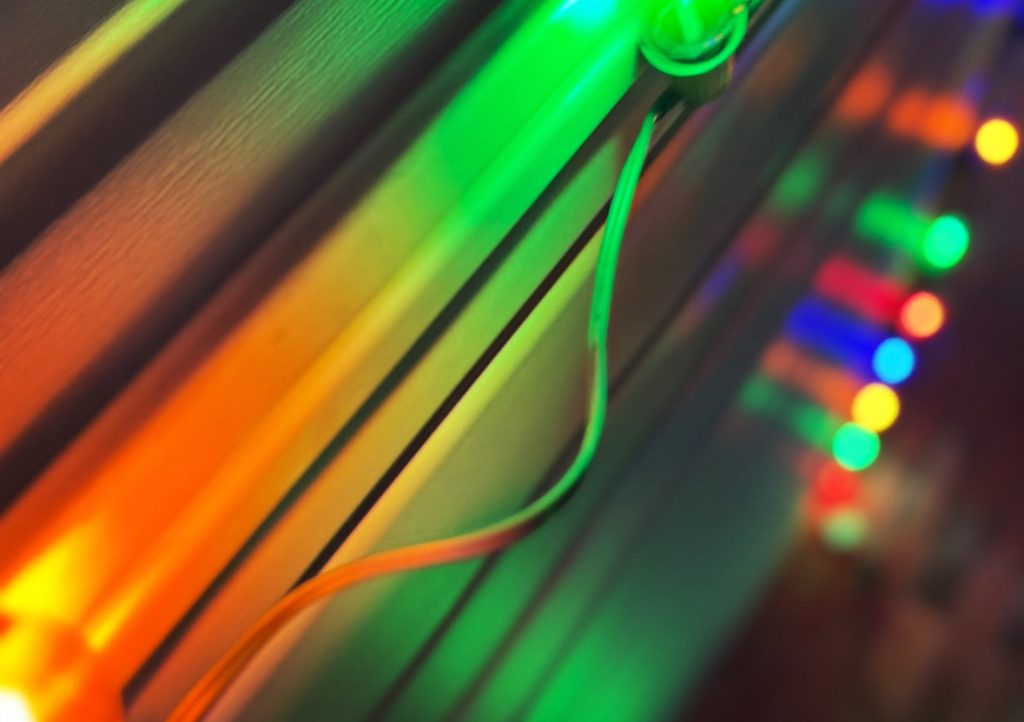 Glowing multicolored lights up on wood, maybe Christmas lights.