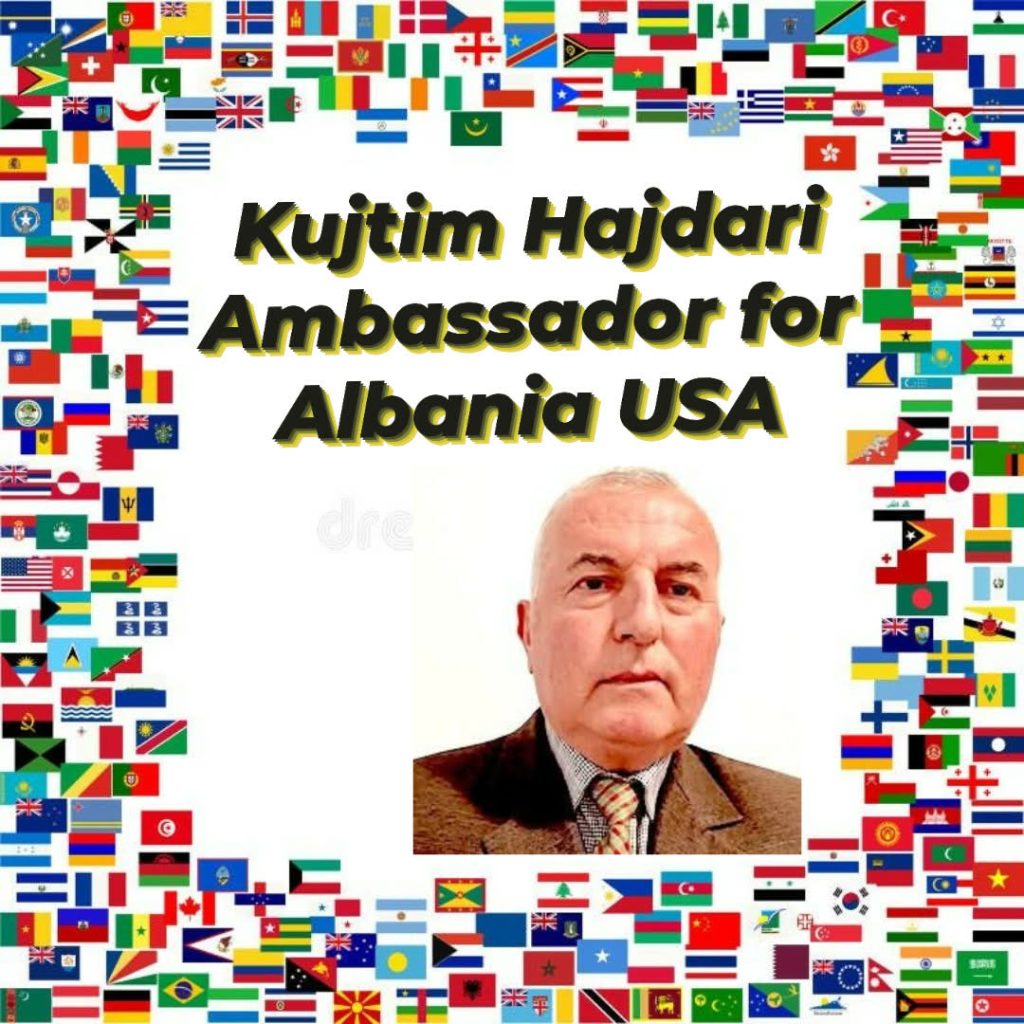 Older Eastern European man with a brown coat and red tie and nearly bald head. 