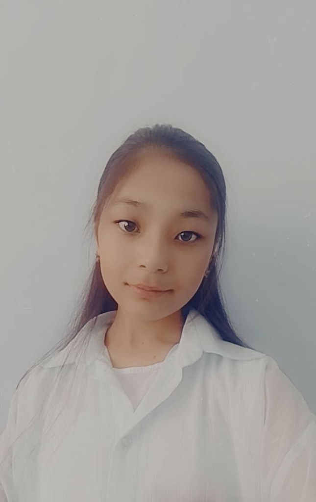 Central Asian woman, young, with long straight dark hair and brown eyes ad a white fluffy blouse.