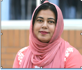 Middle aged South Asian woman with a pink headscarf with white flowers.