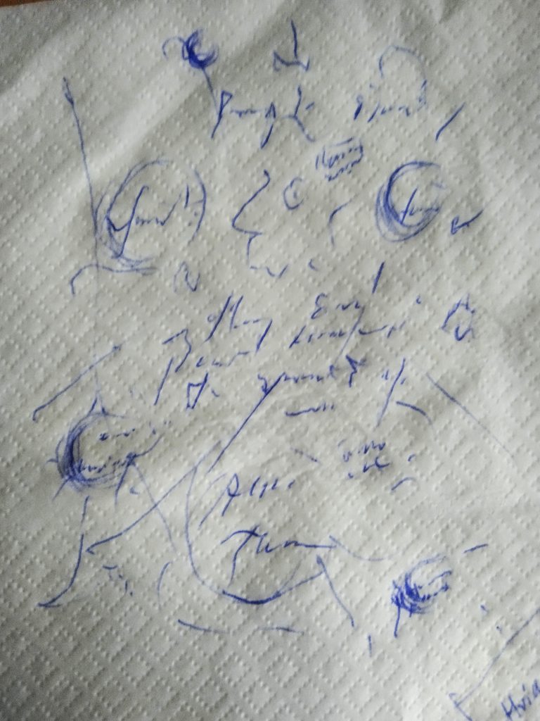 Blue pen scrawls on a napkin