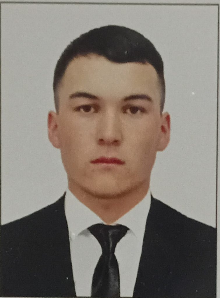Young Central Asian guy with short dark hair and a black suit.