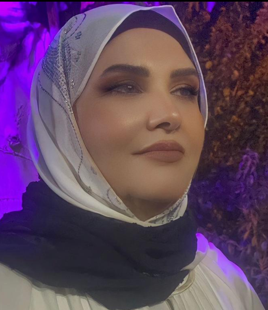 Young Middle Eastern woman with a white and silver headscarf and black outfit photographed under purple light at night.