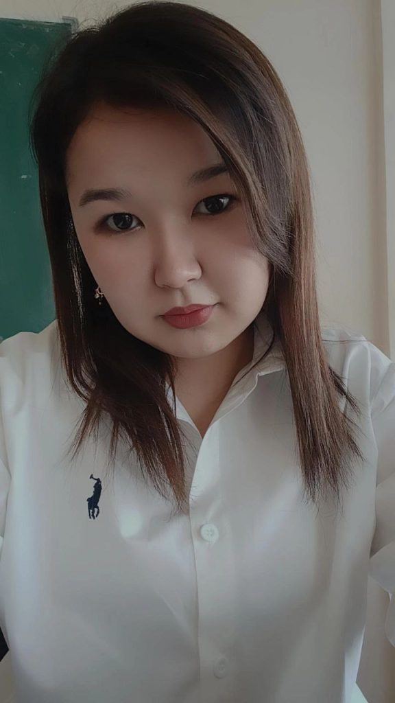 Young Central Asian woman with short straight dark hair, brown eyes, earrings, and a white collared top.