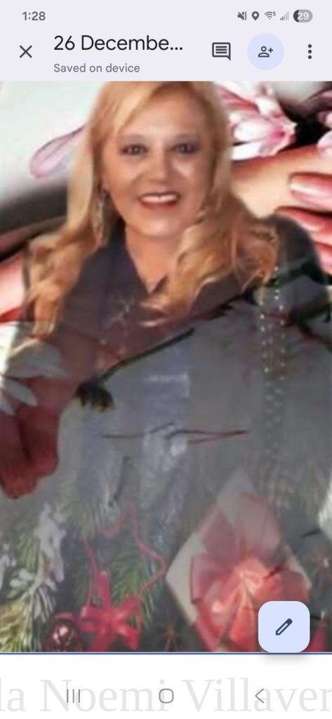 Middle aged Latina woman with mid-length curly light brown hair and a black jacket.